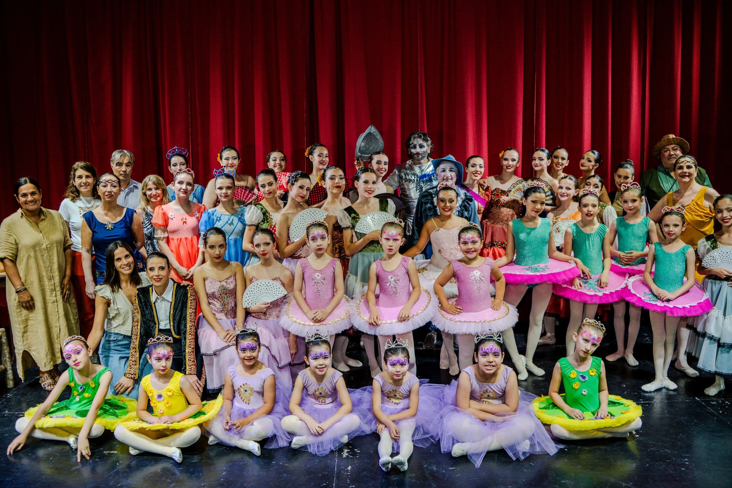 El elenco de la escuela sobre el escenario tras una función, con la directora